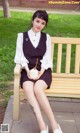 A woman sitting on a bench holding a coconut.