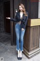 A woman standing in front of a wooden door.