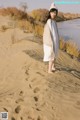 A woman standing on top of a sandy beach.