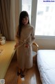 A woman standing in front of a window in a hotel room.