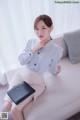 a woman sitting on top of a couch holding a black purse