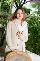 A woman in a white sweater is posing for a picture.